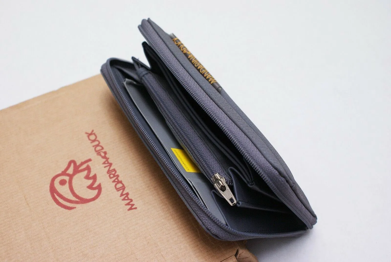 Grey Zip Up Portfolio Wallet With Rubber Tab Logo